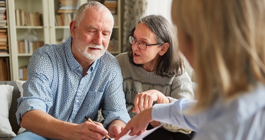 An older couple talking to an attorney